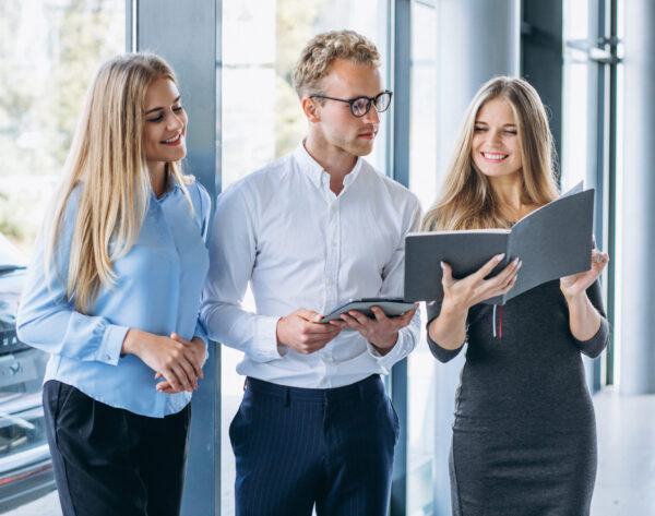 Three collegues working at a car showroom